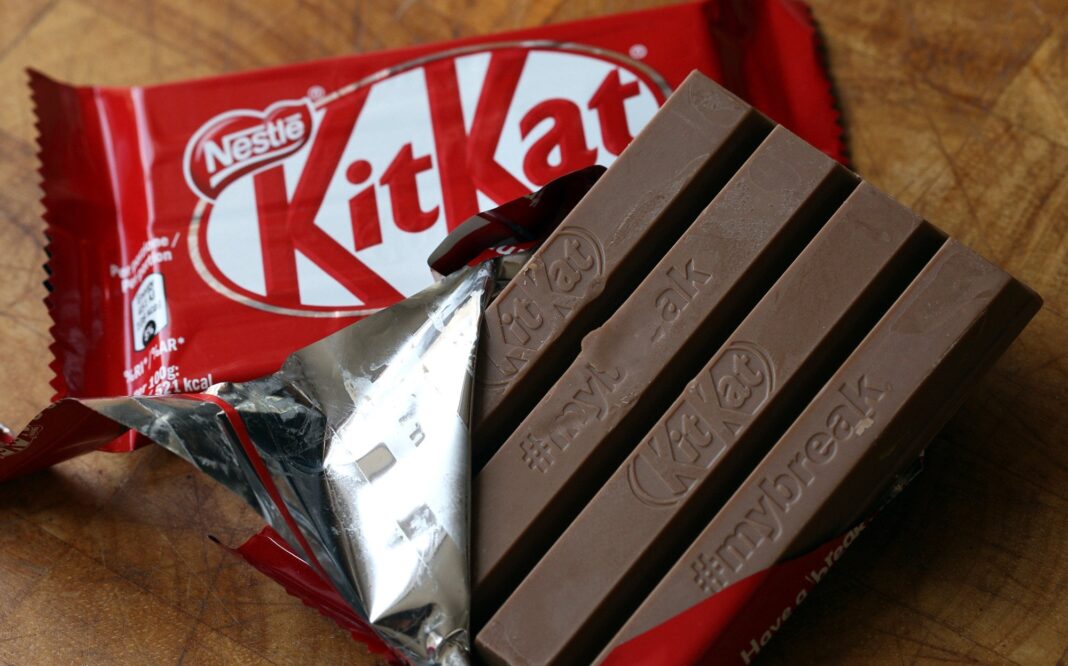 Camión de carga y barras de chocolate KitKat dispersas, ilustrando el robo del cargamento en Europa.