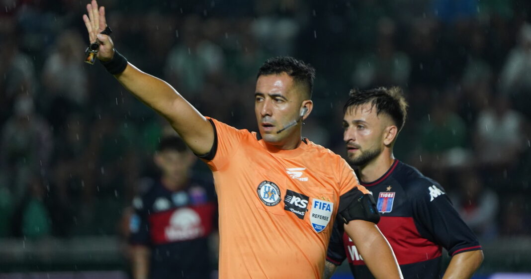 Árbitro utilizando el sistema VAR en un partido de fútbol profesional